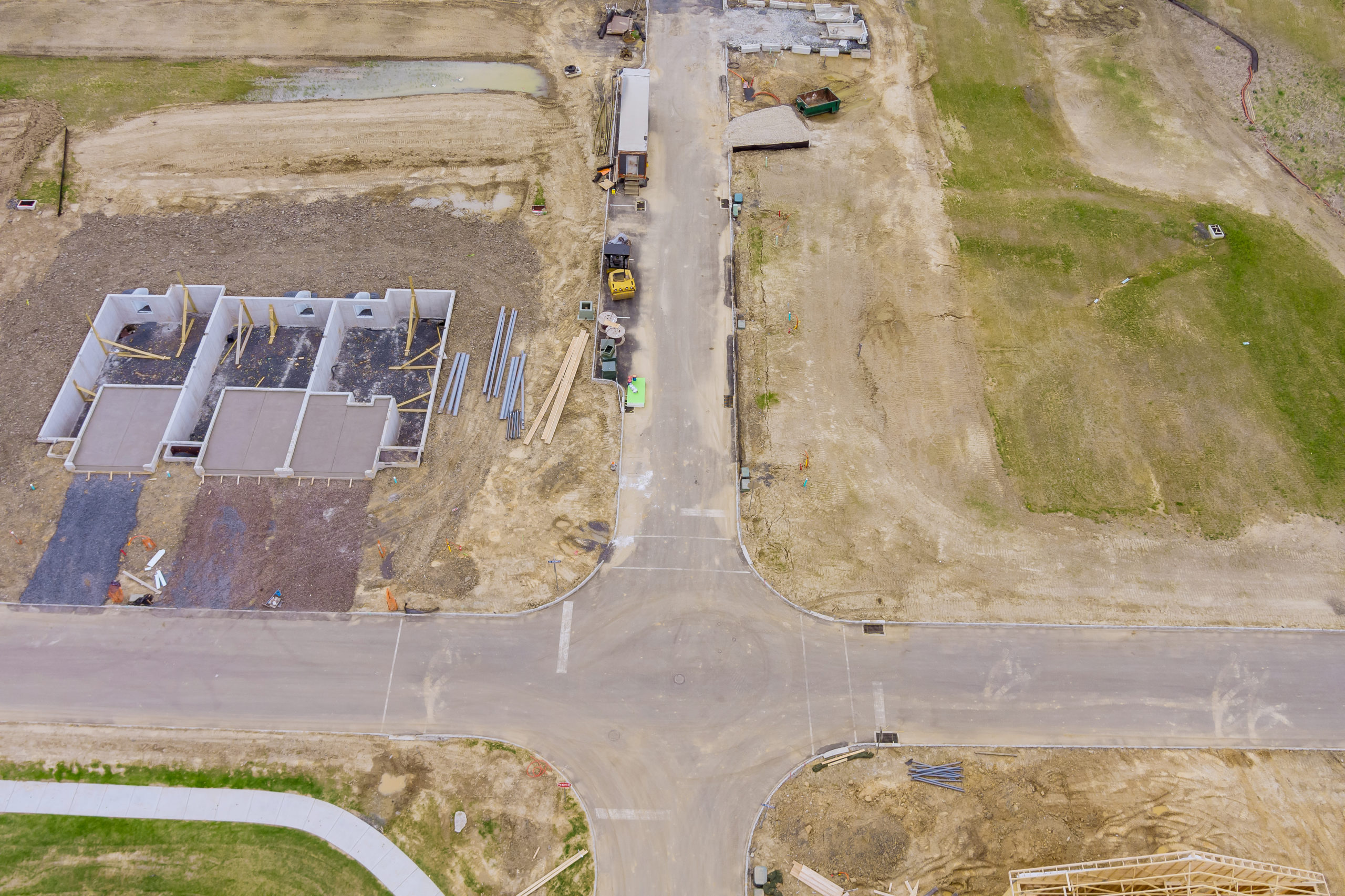 Construction of aerial top view on pouring the foundation for a new building with suburbs